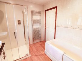 A bathroom with a bathtub and shower at Derwent Cottage in Cockermouth