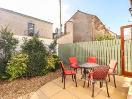 A garden with a table and chairs at Derwent Cottage in Cockermouth