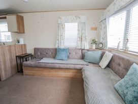 A living room with a sofa and decorative items at 51 Silverbirch Way Rhyl