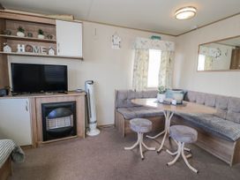 A living room with a television and a dining area at 51 Silverbirch Way in Rhyl