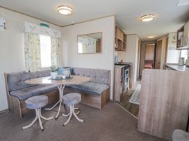 A dining area with a sofa and table at 51 Silverbirch Way, Rhyl