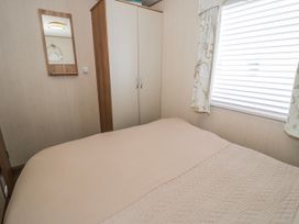 A bedroom with a bed and cupboard at 51 Silverbirch Way Rhyl