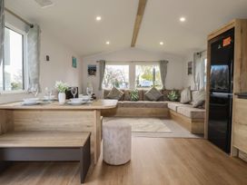 A living room with a dining area and couch at Shamrocks Cove Caravan