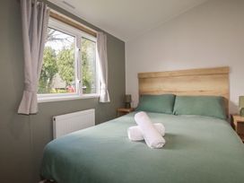 A bedroom with a bed and window at Shamrocks Cove Caravan