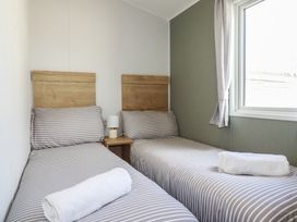 A bedroom with two single beds at Shamrocks Cove Caravan