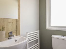 A bathroom with a sink and toilet at Shamrocks Cove Caravan