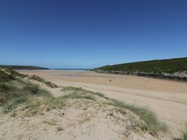 A beach with sand and people at Shamrocks Cove Caravan in 