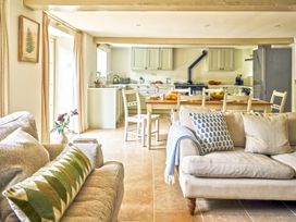 A living room with a sofa and kitchen in Gitcombe Coach House in Totnes