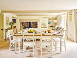 A kitchen with a table, chairs, and flowers at Gitcombe Coach House in Totnes