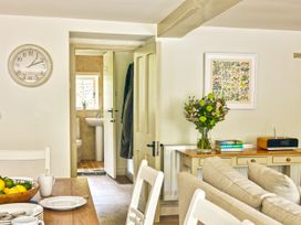 A dining room with a table and flowers at Gitcombe Coach House in Totnes