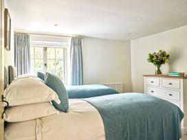 A bedroom with two beds and a dresser at Gitcombe Coach House in Totnes