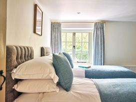Two beds with pillows and a window at Gitcombe Coach House in Totnes