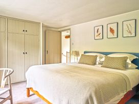 A bedroom with a bed and wardrobe at Gitcombe Coach House in Totnes