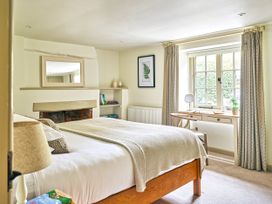 A bedroom with a bed and desk in Gitcombe Coach House, Totnes