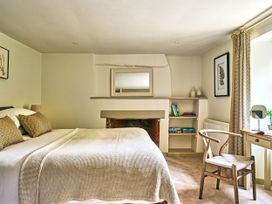 A bedroom with a bed and bookshelf at Gitcombe Coach House in Totnes