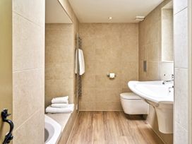 A bathroom with a bathtub, toilet, and sink at Gitcombe Coach House in Totnes
