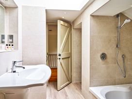 A bathroom with a sink and a bathtub at Gitcombe Coach House in Totnes