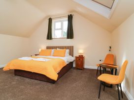 A bedroom with a bed, table, and chair at The Station House in Blackmoor Gate near Parracombe