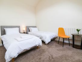 A bedroom with two beds and a table with flowers at The Station House near Blackmoor Gate