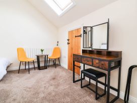 A bedroom with a dresser, chairs, and a small table at The Station House Blackmoor Gate near Parracombe