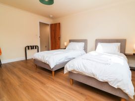 A bedroom with two beds and a coat rack at The Station House Blackmoor Gate near Parracombe