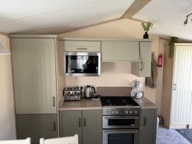 A kitchen with cabinets microwave and stove at Hoburne Blue Anchor - Holiday Accommodation 307 Minehead