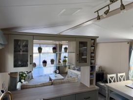 A living room with kitchen cabinets and a dining area at Hoburne Blue Anchor - Holiday Accommodation 307 Minehead