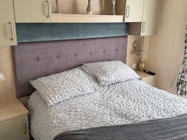 A bedroom with a bed and a bedside table at Hoburne Blue Anchor - Holiday Accommodation 307 Minehead