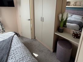 A bedroom with a bed, wardrobe, and a plant at Hoburne Blue Anchor - Holiday Accommodation 307 Minehead