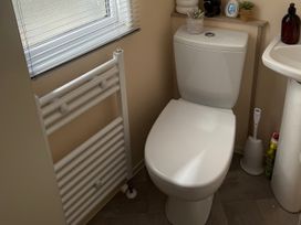 A bathroom with a toilet and radiator at Hoburne Blue Anchor - Holiday Accommodation 307 Minehead