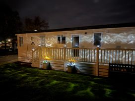 A mobile home with a deck and planters at Hoburne Blue Anchor - Holiday Accommodation 307 Minehead
