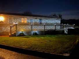 An outdoor area with a holiday home and decking at Hoburne Blue Anchor - Holiday Accommodation 307, Minehead