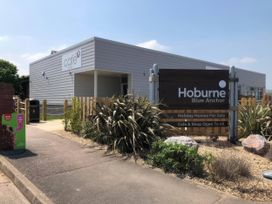 An outdoor view showing a cafe and signage at Hoburne Blue Anchor - Holiday Accommodation 307 Minehead