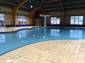 An indoor pool with a ladder and water feature at Hoburne Blue Anchor - Holiday Accommodation 307, Minehead