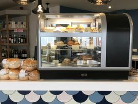 A display case with cakes in a café at Hoburne Blue Anchor - Holiday Accommodation 307 Minehead