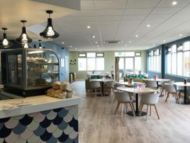 A cafe with tables and chairs at Hoburne Blue Anchor - Holiday Accommodation 307 Minehead