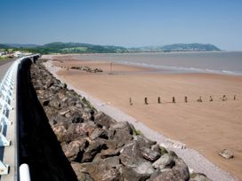 A beach with sand and rocks near a pier at Hoburne Blue Anchor - Holiday Accommodation 307 Minehead