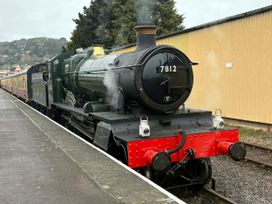 A steam train parked at a railway platform at Hoburne Blue Anchor - Holiday Accommodation 307 Minehead