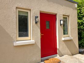 A red door with windows and light fixtures at The Mews @ Suskar, Laragh, County Wicklow