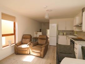 A living room with recliner chairs and a kitchen area at The Mews @ Suskar Laragh, County Wicklow
