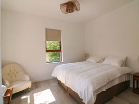 A bedroom with a bed and a chair at The Mews @ Suskar, Laragh, County Wicklow