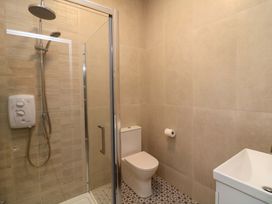 A bathroom with a shower, toilet, and sink at The Mews @ Suskar, Laragh, County Wicklow