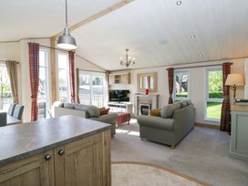 A living room with a sofa, television, and fireplace at Borwick Heights 17 in Carnforth