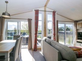 A living room with a sofa and dining area at Borwick Heights 17 in Carnforth
