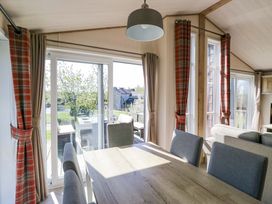 A dining room with a large table and chairs at Borwick Heights 17 in Carnforth