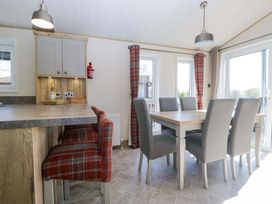 A dining room with a table and chairs at Borwick Heights 17 Carnforth