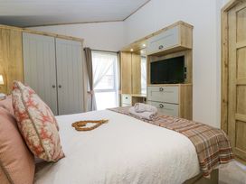 A bedroom with a bed and wardrobe at Borwick Heights 17 in Carnforth