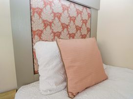 A bed with pillows and a headboard at Borwick Heights 17 in Carnforth