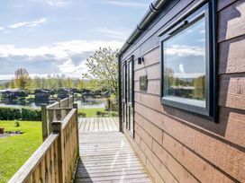 A wooden cabin exterior with deck and view of water at Borwick Heights 17 Carnforth
