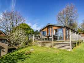 A lodge with a deck and railing at Borwick Heights 17 Carnforth